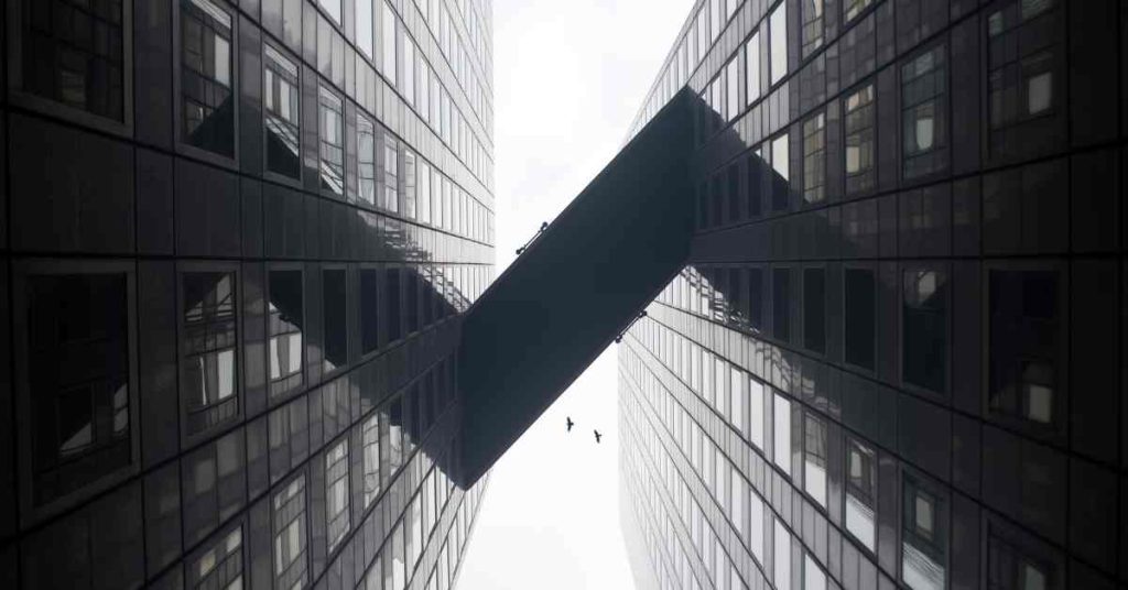 Two glass buildings, with a bridge between the sky scrapers